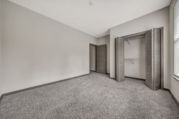 An empty room with a closet and a window